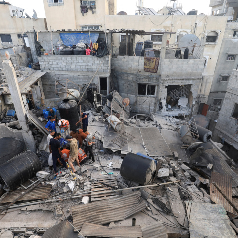 Varios palestinos buscan supervivientes entre los escombros de un edificio atacado por Israel en ciudad de Gaza.