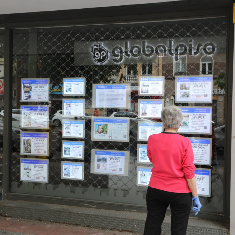 Una mujer echa un vistazo a las ofertas de una agencia inmobiliaria, en una imagen de archivo.
