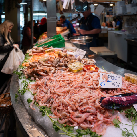 Varias personas en el mercado de abastos realizan sus comprar previas a la Navidad.