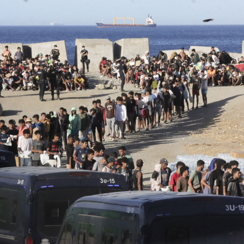 Reparto de alimentos por parte de miembros de Cruz Roja a los migrantes en la playa del Trampolín, este jueves en Ceuta. Reparto de alimentos por parte de miembros de Cruz Roja a los migrantes en la playa del Trampolín, este jueves en Ceuta.