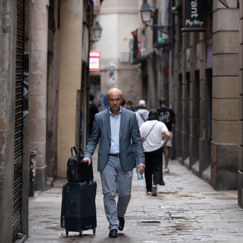 Imagen de archivo de una persona caminando con una maleta en el centro de Barcelona.
