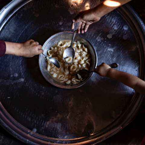 Una familia de los campamentos del noroeste de Siria come un plato de pasta