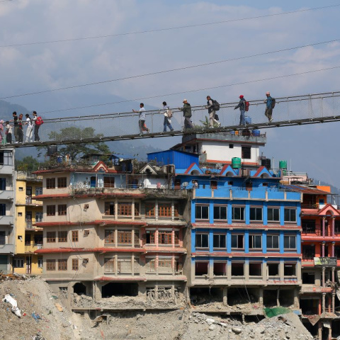 Imagen de archivo de varias personas cruzando un puente colgante instalado tras las inundaciones en la región fronteriza entre el Tíbet y Nepal.