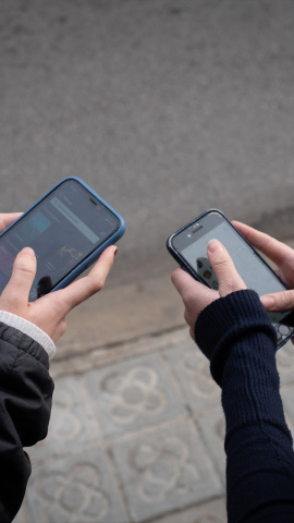Dos personas utilizando el teléfono móvil en Barcelona, Catalunya.
