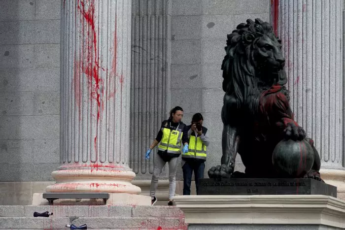 Un grupo de activistas climáticos tiñe de rojo la fachada del Congreso: así han quedado los leones