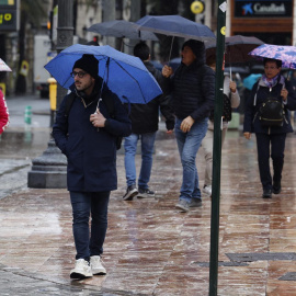 Algunas personas caminan bajo la lluvia en València, a 1 de enero de 2025.