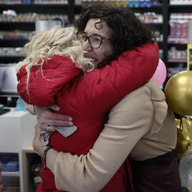 Beatriz Rodríguez (d), dueña de la administración de San Sebastián de los Reyes que ha vendido parte del número 06.766 agraciado con el segundo premio, abraza a Merche, una de sus empleadas.