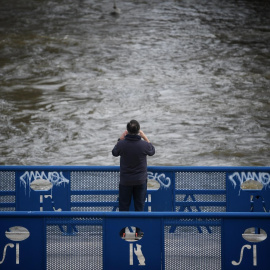 Una persona fotografía la crecida del río Manzanares, a 20 de marzo de 2025.
