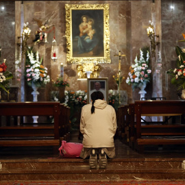 Una mujer reza ante el altar abierto por el fallecimiento del Papa Francisco I en la Nunciatura Apostólica.