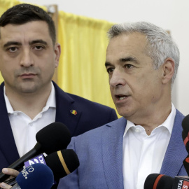 El candidato presidencial y líder del partido de extrema derecha Alianza para la Unión de Rumanos (AUR), George Simion (izq.), y el candidato inhabilitado Calin Georgescu hablan con los periodistas después de emitir sus votos.