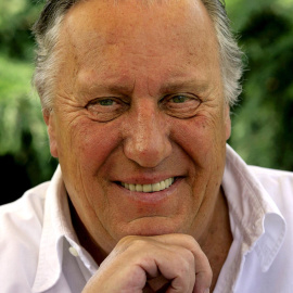 FILE PHOTO: British novelist Frederick Forsyth smiles during an interview with Reuters at his home near Hertford, England, July 26, 2006. Since the end of the Cold War thriller writers have been searching for a theme to replace it, and novelist Frederick Forsyth believes they may have found it in global terrorism. Picture taken July 26, 2006. REUTERS/Kieran Doherty  (BRITAIN)/File Photo