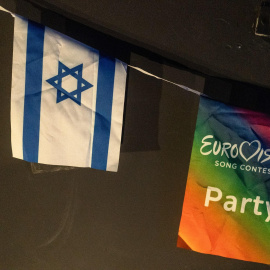 Una bandera israelí junto al logo de Eurovisión durante la proyección de la final del Festival de la Canción de 2025, en un centro comunitario de Tel Aviv (Israel).