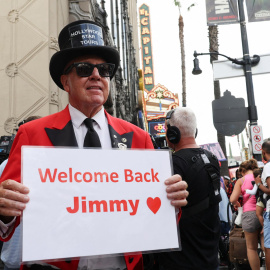El actor Gregg Donavan sostiene un cartel dando la bienvenida a Jimmy Kimmel.