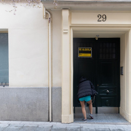 Una persona pasa a un edificio donde hay un cartel de ‘Se alquila’,