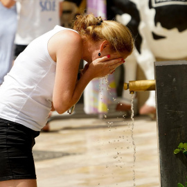 Una mujer se refresca en una fuente en València, en una imagen de archivo.
