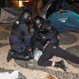 La Policía deteniendo a una persona en la acampada de Lisboa, este sábado.