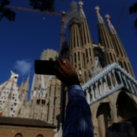 Un hombre toma una imagen con su smartphone de la Sagrada Familia, en Barcelona. REUTERS