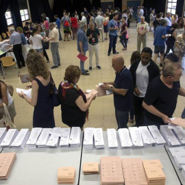 Varios ciudadanos eligen las papeletas en un colegio electoral. EFE/Quique García