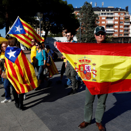 Un hombre sostiene una bandera española junto a personas con banderas estelades, que participaban en la marcha por el derecho a decidir de este fin de semana en Madrid. REUTERS / Juan Medina