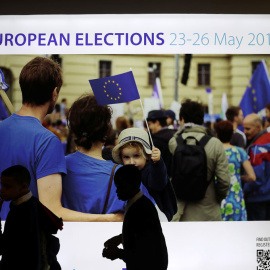 Varias personas pasan por una pantalla que muestra un anuncio de las elecciones de la UE en el Parlamento Europeo en Bruselas. REUTERS / Yves Herman