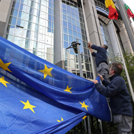 Varios operarios colocan una bandera de la UE en la fachada del Parlamento Europeo, en Bruselas. REUTERS/Yves Herman