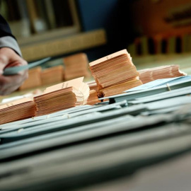 Una persona elige sus papeletas para el 26-M en un colegio electoral de Pamplona. EFE/ Villar López