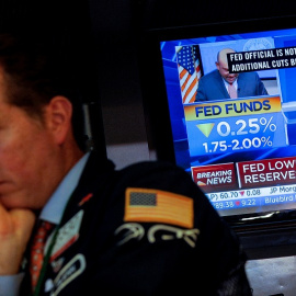 La noticia de la rebaja de los tipos de interés en EEUU en un monitor de televisión en el patio de negociación de la Bolsa de Nueva York.. REUTERS/Brendan McDermid