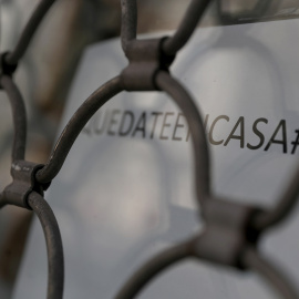 Un letrero con el lema 'Quédate en casa' en el escaparate de un comercio cerrado en Madrid. REUTERS/Susana Vera