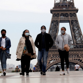 Personas con mascarilla pasean cerca de la Torre Eiffel, en París. . REUTERS/Gonzalo Fuentes