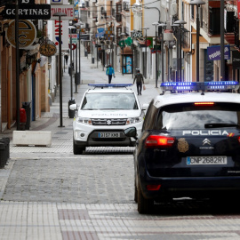 Un coche de la Policía Nacional se cruza con otro de la Policía Local, en una céntrica calle de la localidad malagueña de Ronda, durante el estado de alarma por la pandemia del coronavirus. REUTERS/Jon Nazca