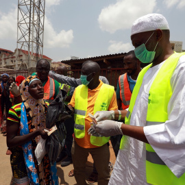 Una cola de personas para recibir ayuda alimentaria durante las medidas confinamiento por la pandemia del coronavirus, en Abuja, Nigeria. REUTERS / Afollabi Sotunde