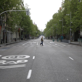 Un hombre cruza la madrileña calle de Serrano, prácticamente desértica, durante el estado de alarma por la pandemia del coronavirus. REUTERS/Sergio Perez