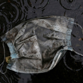 Una mascarilla, tirada en un charco en el suelo, en Madrid, durante el estado de alarma por la pandemia del coronavirus. REUTERS/Susana Vera