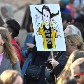 Jóvenes manifestantes en el centro de Estocolmo, en la jornada de huelga estudiantil por la crisis climática, llevan una pancarta con la imagen de la activista Greta Thunberg, impulsora del movimiento Friday For Future. EFE / EPA / Claudio Bresciani