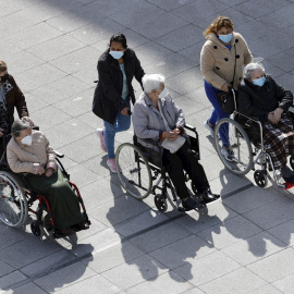  Tres mujeres dependientes pasean con sus cuidadoras por las calles de Bilbao. EFE/LUIS TEJIDO