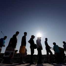 Refugiados y migrantes del campo de Moria hacen cola para entrar en un nuevo campamento en la isla de Lesbos. REUTERS/Yara Nardi