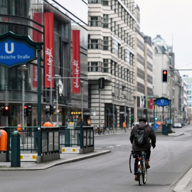 Un hombre marcha en bicicleta por una desértica Friedrichstrasse, una de las principales arterias comerciales de Berlín, durante la pandemia del coronavinur. REUTERS/Annegret Hilse