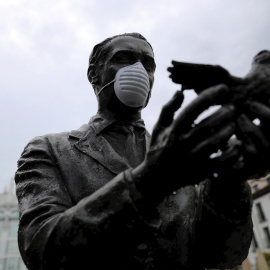 La estatua de Federico García Lorca, en la madrileña plaza de Santa Ana, ataviada con una mascarilla facial durante una nueva jornada de confinamiento por la crisis del coronavirus. EFE/Rodrigo Jiménez