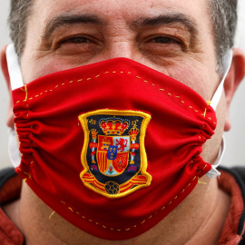 Un hombre, con una mascarilla casera con el escudo de la selección española de fútbol. REUTERS/Jon Nazca