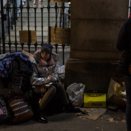 Una niña espera sentada sobre sus maletas a que los trabajadores del Samur Social de Madrid confirme si su familia, procedente de Georgia, tendrá plaza en un albergue para pasar la noche mientras formalizan su solicitud de protección internacional.- JA