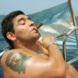 Diego Armando Maradona, con un tatuaje del Che Guevaraen el brazo, fuma un puro cohiba en un barco en aguas de La Habana, en una foto de abril de 2000. REUTERS