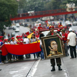  Venezolanos durante una celebración sosteniendo el retrato de Simón Bolivar en una imagen de archivo.- EFE