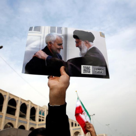 Una persona que sostiene una imagen que muestra al líder supremo iraní, ayatolá Ali Khamenei, con el teniente general de la Guardia  Revolucionaria Qasem Soleimani, en  una manifestación anti-estadounidense para condenar el asesinato de Soleimani. EFE