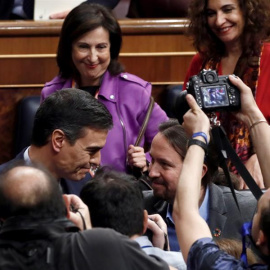 Pedro Sánchez es felicitado por el líder de Unidas Podemos, Pablo Iglesias, tras lograr la confianza del Congreso para un nuevo mandato como presidente del Gobierno. EFE/ Mariscal