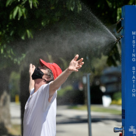 Un hombre se refresca en una estación de nebulización, en medio de la ola de calor extremo en Vancouver (Columbia Británica, Canadá). REUTERS/Jennifer Gauthier