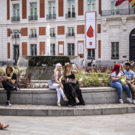 Varias personas en la fuente de la Puerta del Sol. E.P./Alejandro Martínez Vélez