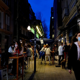 Personas con mascarilla por la calle y en las terrazas de los bares reabiertos en Bilbao. REUTERS/Vincent West