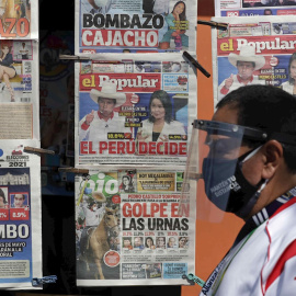 Un hombre pasa por delante de un quiosco de prensa, con las portadas de los diarios que recogen los resultados de la primera vuelta de las elecciones presidenciales. EFE/Paolo Aguilar