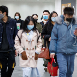Varias personas con máscaras en un túnel del metro en hora punta en Pekín. REUTERS / Thomas Peter