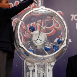 Uno de los niños de San Ildefonso intruduce las bolas en el bombo para el sorteo de la lotería de El Niño. EFE/ Zipi
